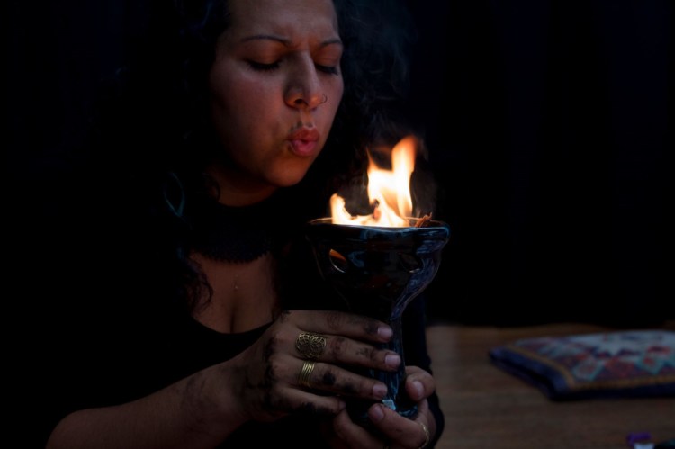 Foto de una persona con una copa con fuego.